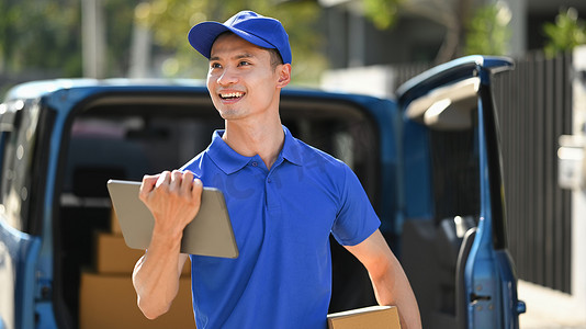手持数字平板电脑和包裹盒的送货服务快递员。