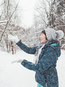 微笑的女人正在玩雪。