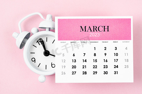 2023 年 3 月日历年，粉红色背景闹钟。