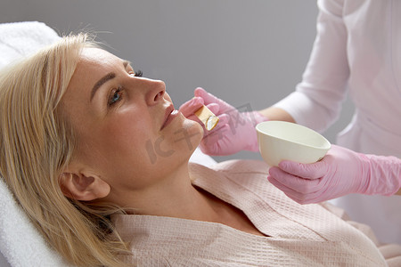 医学美容摄影照片_美容师在现代美容诊所进行激光治疗前应用凝胶 o 女性面部