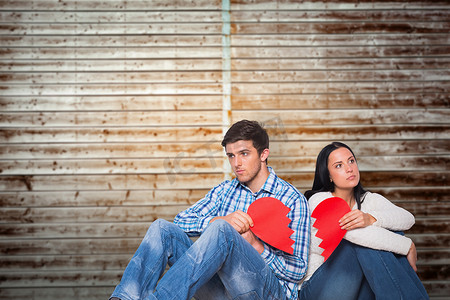 心碎的人摄影照片_年轻夫妇坐在地板上心碎的合成图像