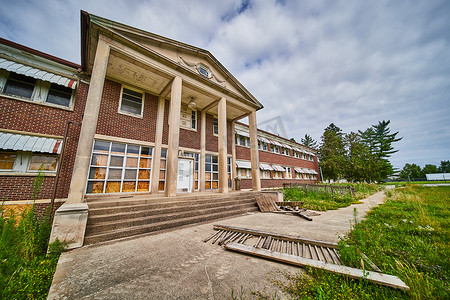 柱子和台阶标志着美国中西部巨大废弃医院大楼的入口