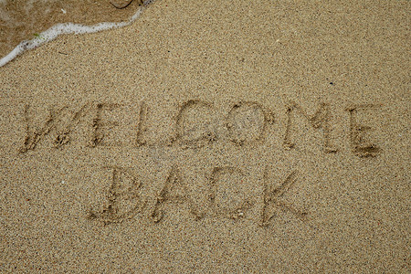 欢迎回来，沙滩上的文字，流行病概念后的旅游
