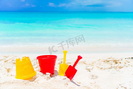 沙滩背景摄影照片_在白色沙滩背景海的孩子的海滩玩具