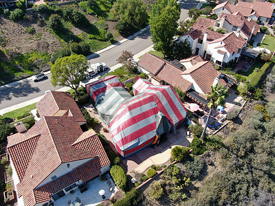 草本熏蒸摄影照片_在被白蚁熏蒸时覆盖着红色帐篷的住宅别墅的鸟瞰图。