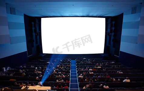 观看电影摄影照片_有放映机光的戏院观众席。