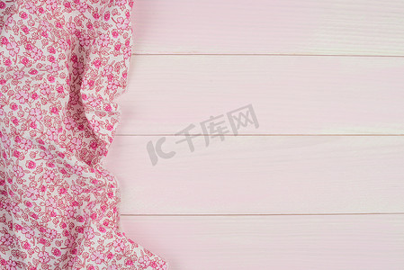 粉色方格背景摄影照片_木桌上的粉色毛巾