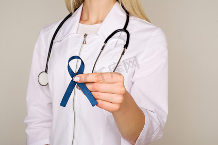 医生手拿着蓝丝带、糖尿病和结直肠癌意识