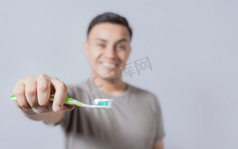 显示有牙膏的微笑的年轻人牙刷被隔绝。