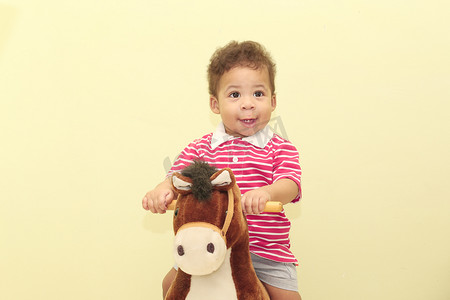 一个可爱的非洲男孩在他的马玩具中的肖像。