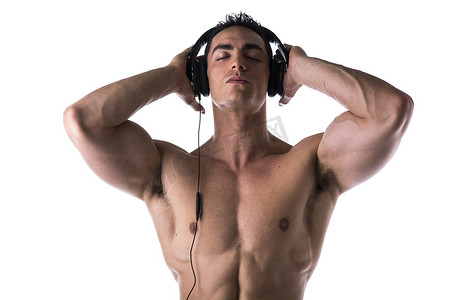 肌肉男成人摄影照片_肌肉男光着膀子，戴着耳机听音乐