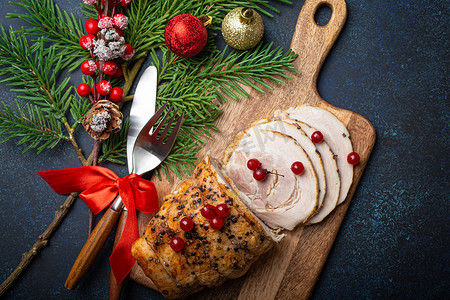 圣诞烤火腿切片配红浆果和节日装饰