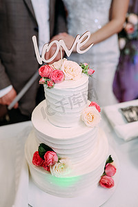 多层婚礼蛋糕摄影照片_漂亮的多层婚礼蛋糕，上面刻着爱