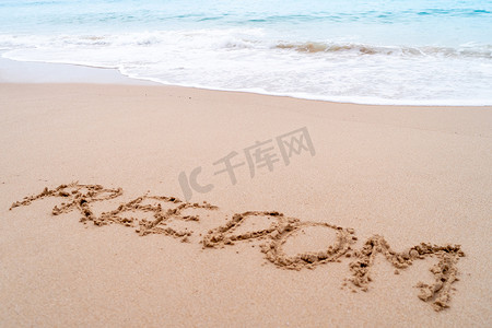 手绘海滩背景摄影照片_自由词手绘在沙滩上的夏日海滩上。