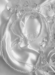 白色丝绸或缎子上的白色珍珠和珍珠珠作为婚礼