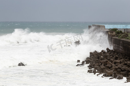 在台风期间的风雨如磐的海，在障碍墙壁上碰撞的波浪