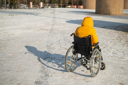 身无分文摄影照片_冬天坐在轮椅上的无家可归的妇女。
