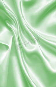 布匹丝绸摄影照片_作为背景的光滑的典雅的绿色丝绸或缎子