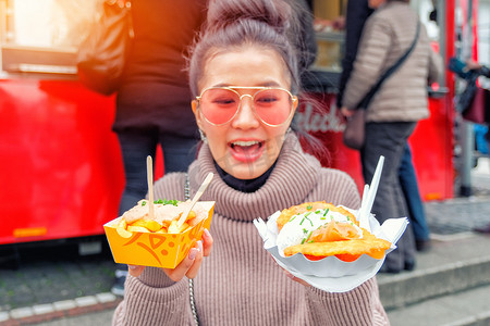年轻女子在德国吃炸薯条和鲑鱼街头食品