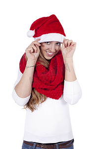 圣诞帽围巾摄影照片_戴着红围巾和圣诞帽的年轻漂亮女人