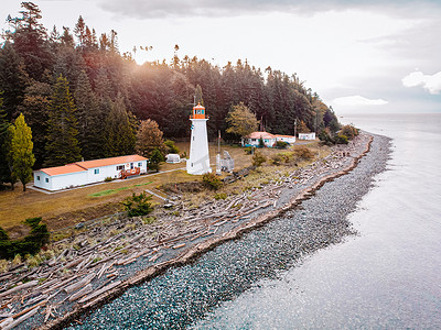 黄色五角星边框摄影照片_加拿大温哥华岛，Quadra Island 老历史灯塔在马奇角夫妇在海岸风暴期间穿着黄色雨衣