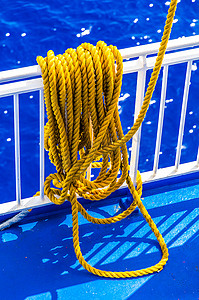 书本打光摄影照片_黄色编织绳索搭在船栏杆上