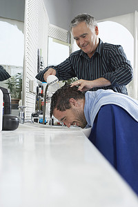 男士发型摄影照片_高级理发师在美发沙龙为男士洗头