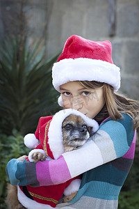 女孩和狗摄影照片_戴着圣诞帽的女孩和狗