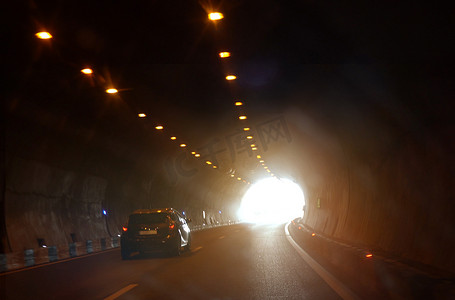 一辆汽车正驶向隧道出口。