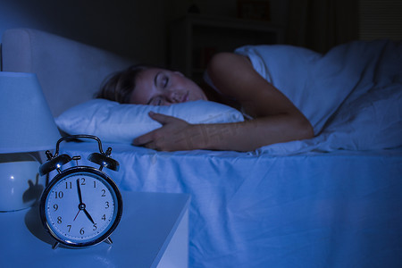 女人熟睡摄影照片_专注于熟睡女人面前的闹钟