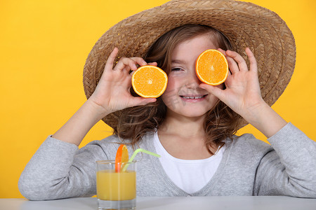 小女孩玩橙子喝橙汁