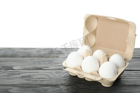 白色背景下木桌纸盒中的生鸡蛋很少