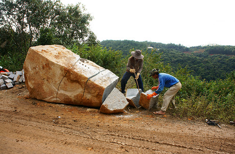 大型工程摄影照片_工人们劈开大块岩石进行道路工程