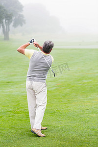 高尔夫球手在球场上挥动球杆