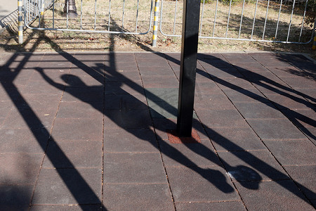 一个人在公园里做单杠的影子。