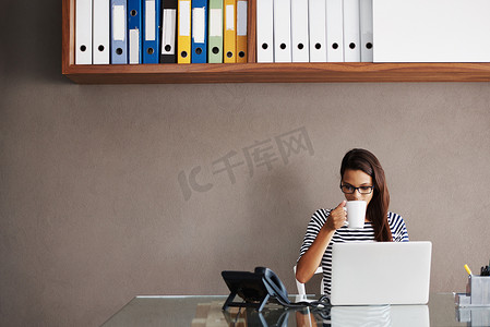 办公室里的咖啡、笔记本电脑和女商人，负责规划、管理和检查墙壁背景上的电子邮件。
