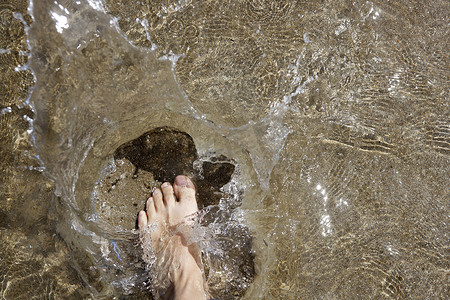 动感水纹水花摄影照片_走在岸浅水的海滩游人脚