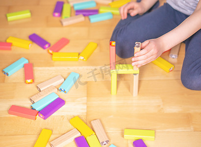 公寓地上的孩子在玩五颜六色的玩具积木。