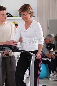 电商活动闪屏摄影照片_在健身房里有教练的女人