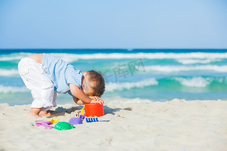 在海滩上玩玩具的男孩
