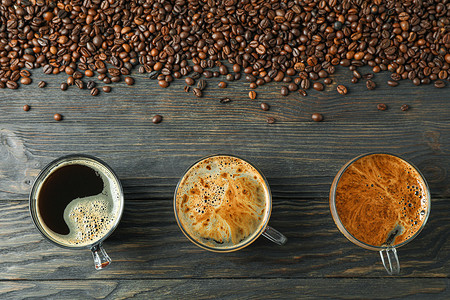 饮料组合摄影照片_木桌上放着咖啡和咖啡豆的平铺组合物，顶视图