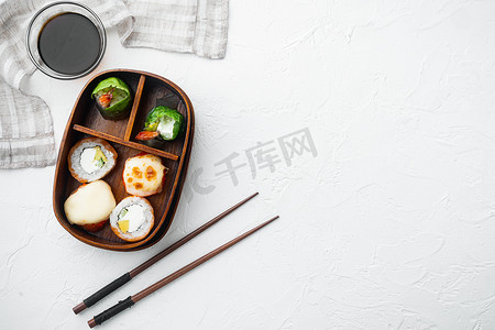餐盒摄影照片_日本餐盒便当配寿司卷 eice 鳄梨鲑鱼，白石背景，顶视图平躺，带复制空间和文本空间