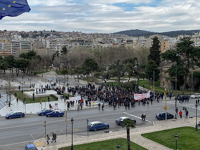 希腊塞萨洛尼基，抗议者手持海报在市中心移动。