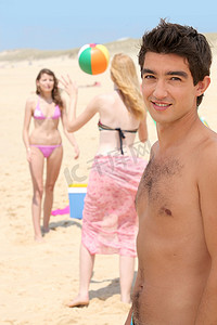 青少年低度近视摄影照片_三个少年在沙滩上玩球