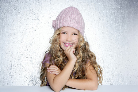粉红色帽子摄影照片_微笑手势小女孩冬季粉红色帽子肖像