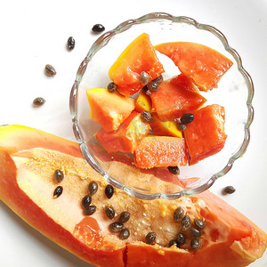 橙色鲜木瓜保存在白色背景中，碗中有切块，富含纤维 维生素 C 和抗氧化剂 增强免疫力 对糖尿病患者和眼睛有益