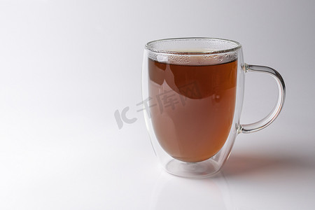 泡水喝摄影照片_白色背景中带红茶的玻璃保温杯