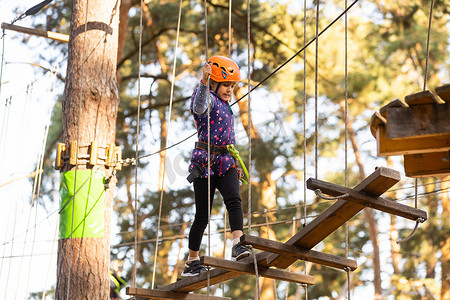 冒险乐园中的女孩攀爬是一个可以包含多种元素的地方，例如绳索攀爬练习、障碍训练场和高空滑索。