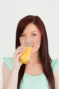 喝一杯橙汁的好看的红发女人我