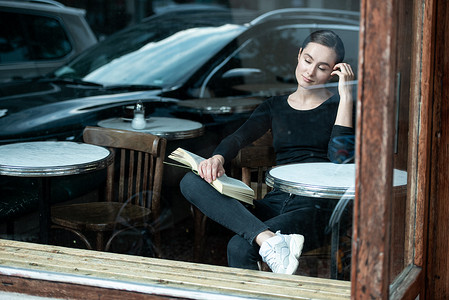 人群交谈摄影照片_女人在咖啡店看书喝咖啡看书
